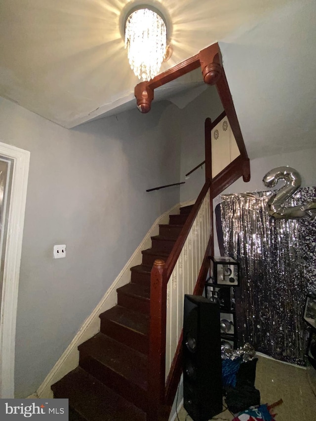 staircase featuring carpet and a notable chandelier