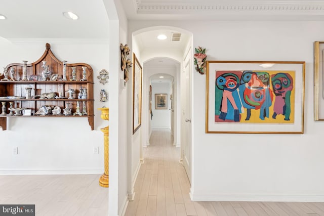 hall featuring light hardwood / wood-style floors and crown molding