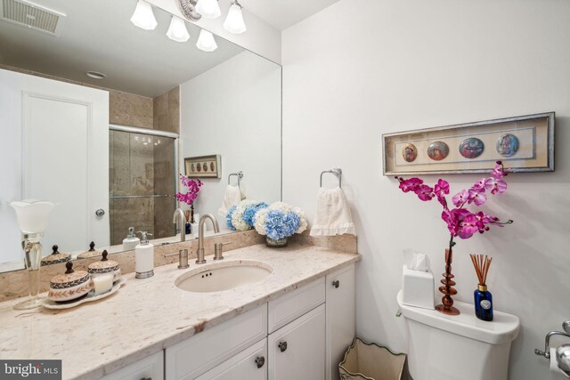 bathroom with walk in shower, vanity, and toilet