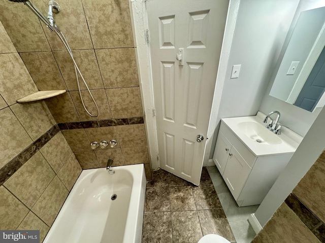 bathroom featuring vanity and tiled shower / bath