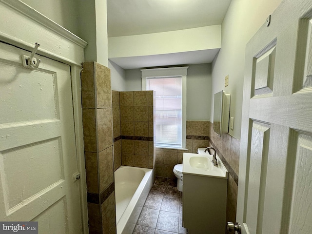 bathroom with tile patterned floors, vanity, tile walls, toilet, and a tub