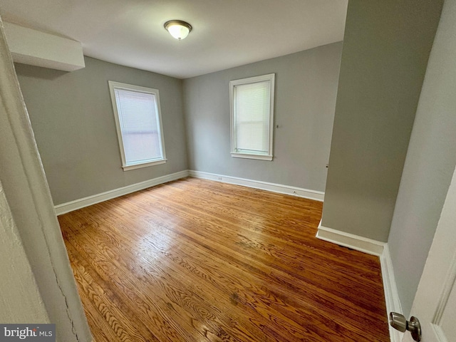 unfurnished room with wood-type flooring