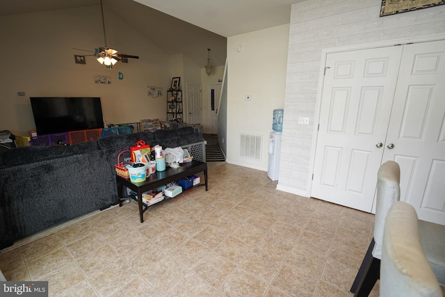 tiled living room featuring ceiling fan and lofted ceiling