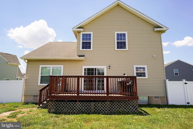 back of property with a wooden deck and a yard