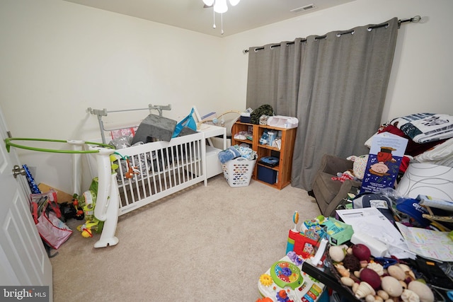 carpeted bedroom featuring a nursery area