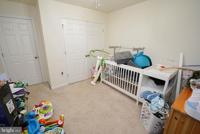 carpeted bedroom featuring a nursery area and a closet