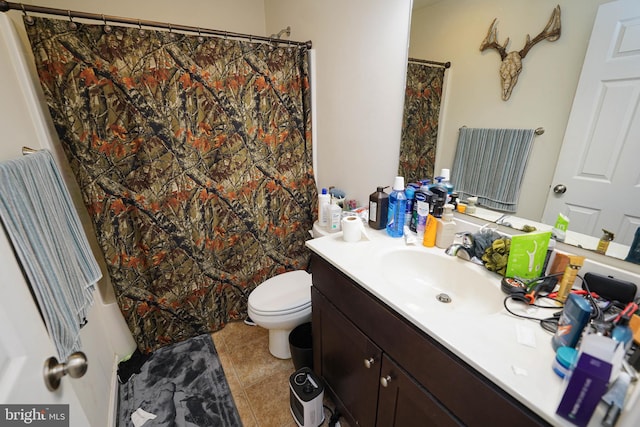 bathroom featuring tile patterned flooring, vanity, and toilet