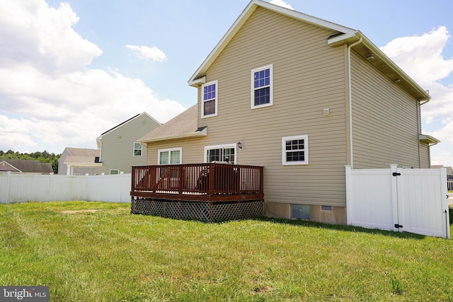 back of property featuring a wooden deck and a yard