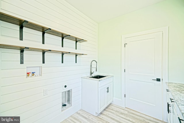 laundry room featuring cabinets, hookup for a washing machine, light wood-type flooring, electric dryer hookup, and sink