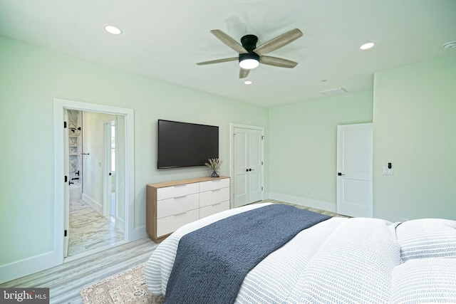 bedroom with ensuite bath, ceiling fan, and light hardwood / wood-style floors