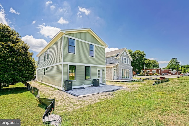 rear view of property with a yard, cooling unit, and a patio