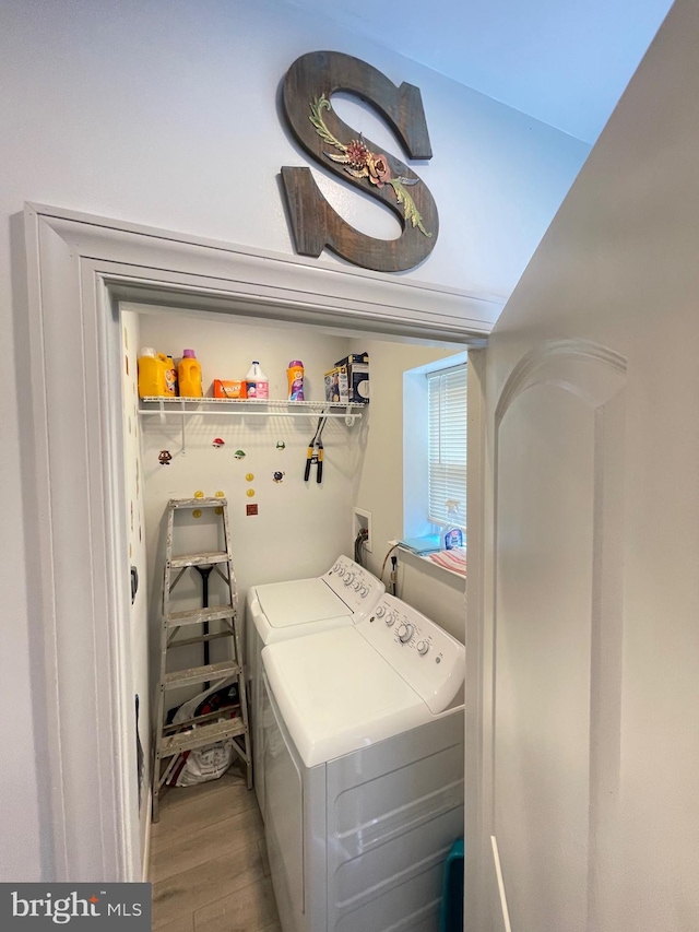 laundry room with washer and clothes dryer and light hardwood / wood-style flooring