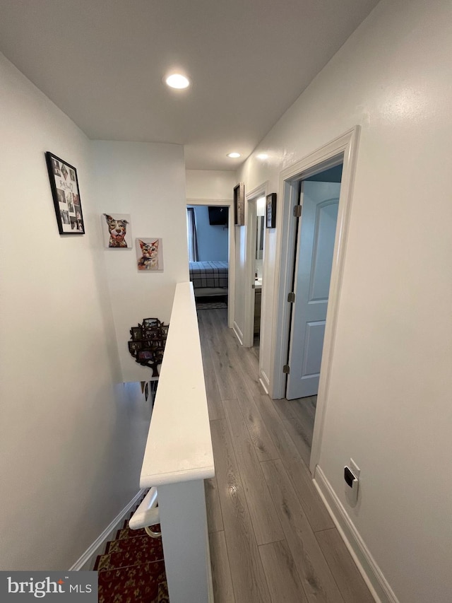 corridor with hardwood / wood-style flooring