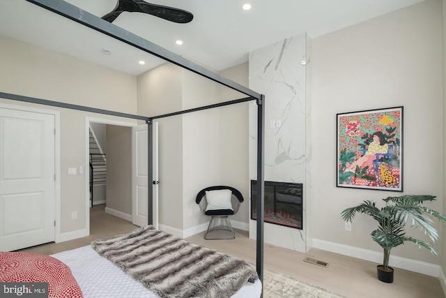 bedroom featuring ceiling fan and a high end fireplace