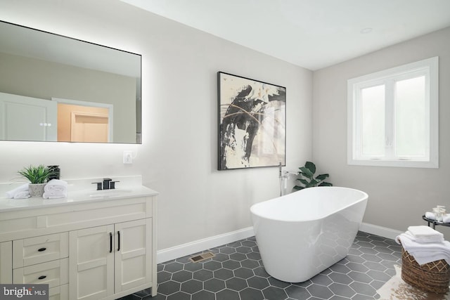 bathroom featuring a bathing tub, vanity, and tile patterned floors