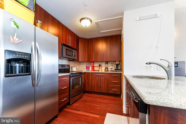 kitchen featuring light stone countertops, decorative backsplash, stainless steel appliances, dark wood-type flooring, and sink