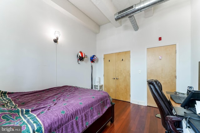 bedroom featuring dark hardwood / wood-style flooring and a high ceiling