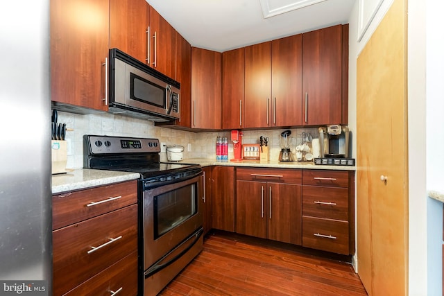 kitchen with dark hardwood / wood-style floors, light stone countertops, backsplash, and appliances with stainless steel finishes