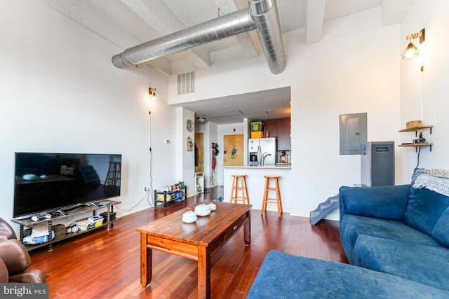 living room featuring electric panel, dark hardwood / wood-style floors, and a high ceiling