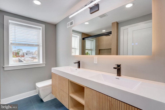 bathroom featuring tile patterned flooring, vanity, toilet, and a shower with door