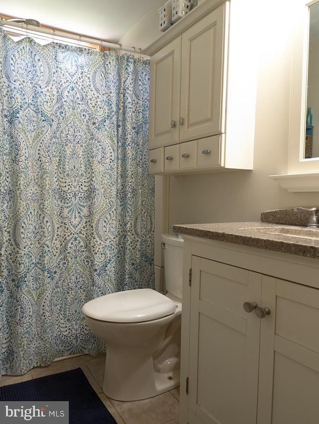 bathroom with tile patterned floors, vanity, toilet, and walk in shower