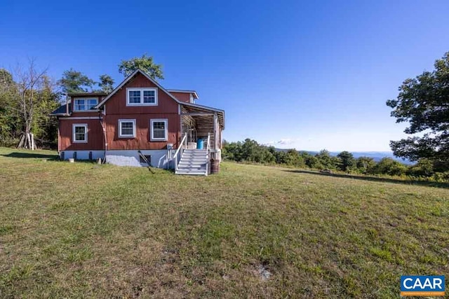 rear view of property with a lawn