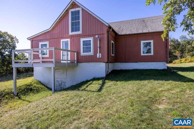 view of side of property with a lawn and a deck