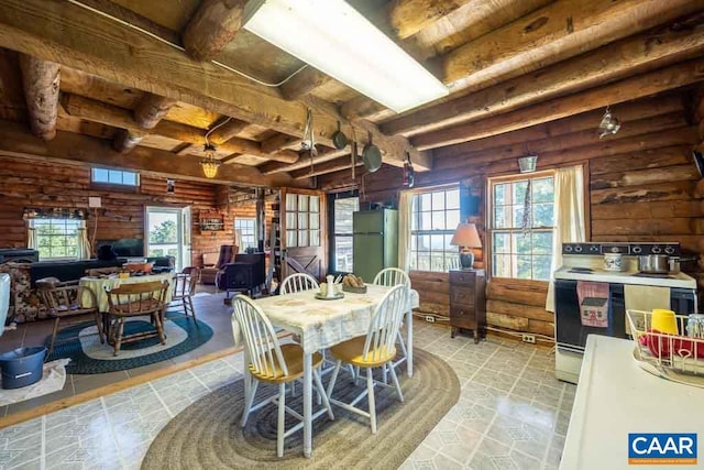 tiled dining area featuring beam ceiling and rustic walls