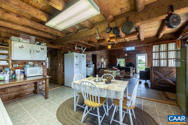 dining area featuring beamed ceiling and light tile patterned flooring