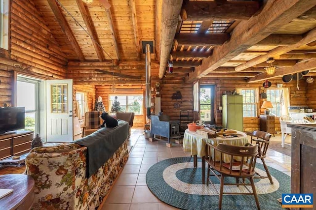 tiled dining space with log walls, lofted ceiling with beams, a wood stove, and wooden ceiling