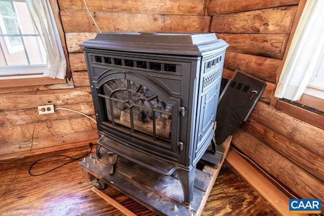 room details with hardwood / wood-style floors and a wood stove