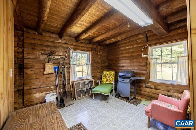 sitting room with beamed ceiling, rustic walls, and wooden ceiling