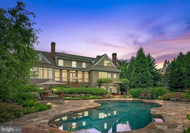 back house at dusk with a patio