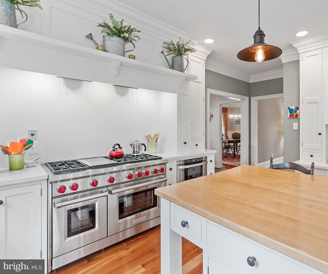 kitchen featuring pendant lighting, white cabinetry, and appliances with stainless steel finishes