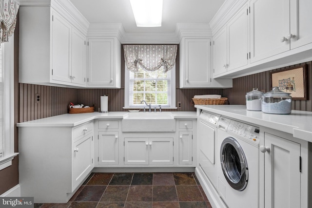 washroom with crown molding, sink, cabinets, and independent washer and dryer