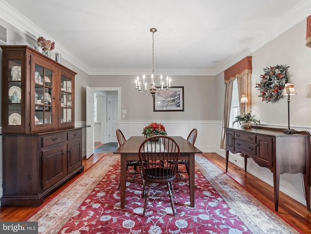 dining room featuring a chandelier, light wood-type flooring, and crown molding