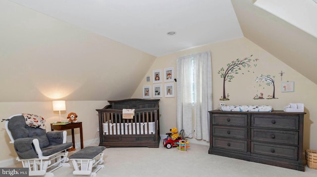 carpeted bedroom featuring a nursery area and lofted ceiling