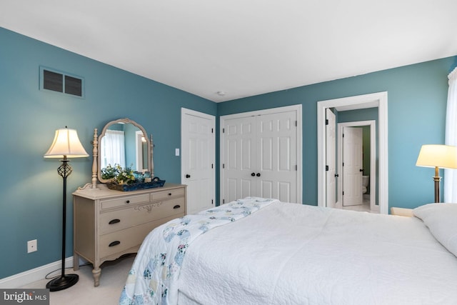 bedroom with light colored carpet and multiple closets