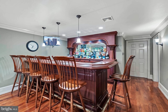 bar featuring decorative light fixtures, dark hardwood / wood-style floors, and ornamental molding