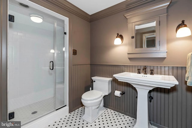 bathroom with tile patterned floors, toilet, an enclosed shower, and ornamental molding