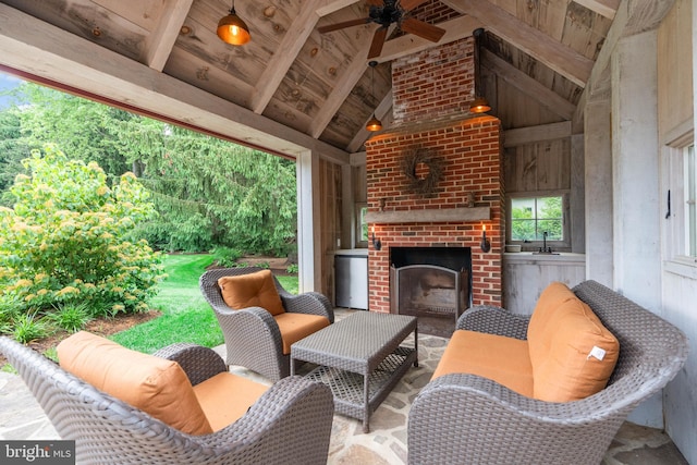 view of patio with ceiling fan, sink, and an outdoor brick fireplace