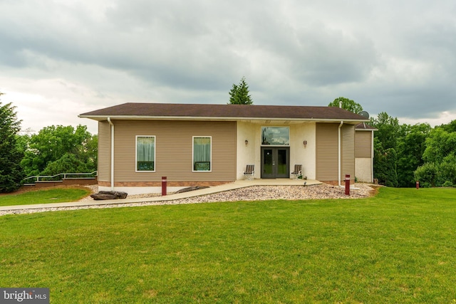 back of house featuring french doors and a lawn