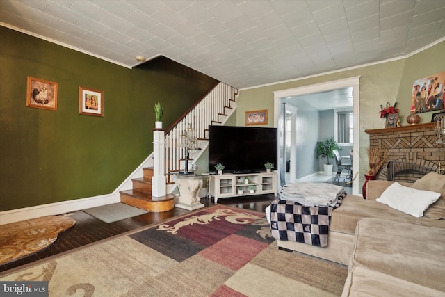 living room featuring a fireplace, hardwood / wood-style floors, and ornamental molding