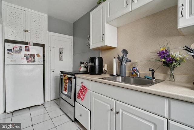 kitchen with white cabinetry, stainless steel range with electric stovetop, and white refrigerator