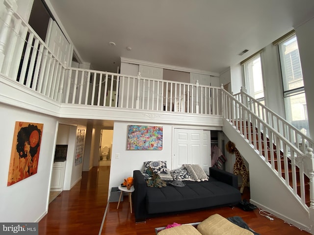 living room featuring dark hardwood / wood-style floors and a towering ceiling