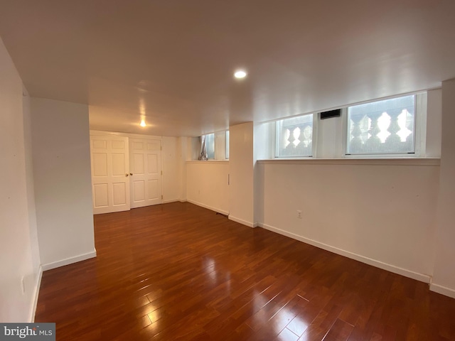 basement with dark hardwood / wood-style flooring