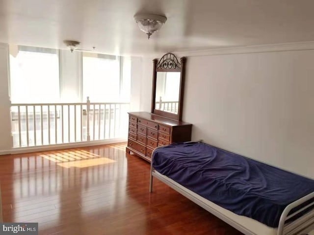 bedroom featuring hardwood / wood-style flooring and crown molding