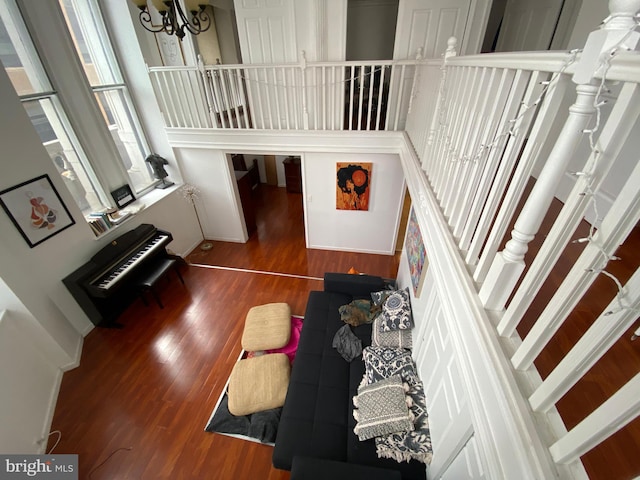 interior space featuring hardwood / wood-style floors, a towering ceiling, and an inviting chandelier