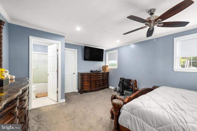 carpeted bedroom featuring ensuite bath, ceiling fan, and crown molding