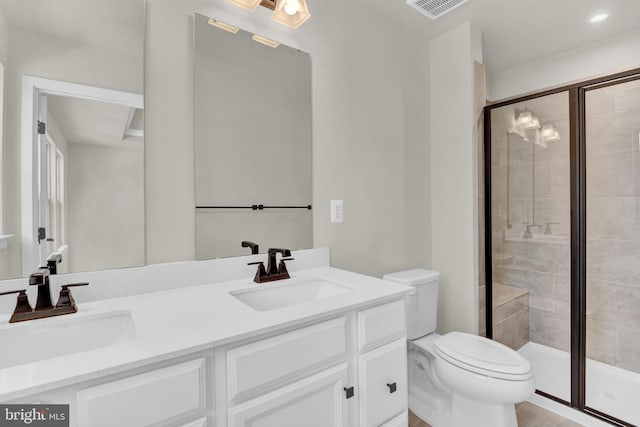 bathroom with vanity, toilet, and a shower with shower door